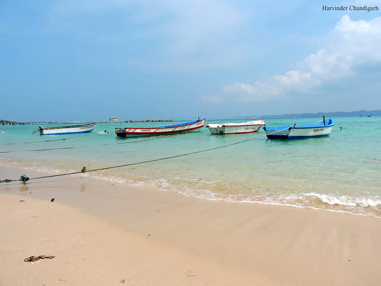 Shallow turquoise waters and glass-bottom boats at Bharatpur Beach in Neil Island
